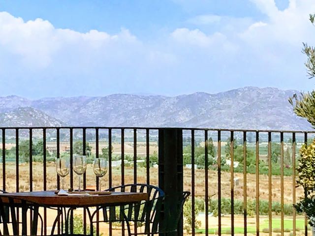 views over the valley with table and wine glasses 