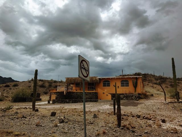 Orange deserted building on Route 1 with grey stormy clouds